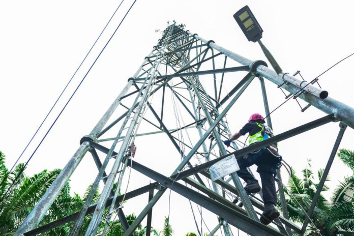 Petugas sedang naik ke tower BTS Indosat